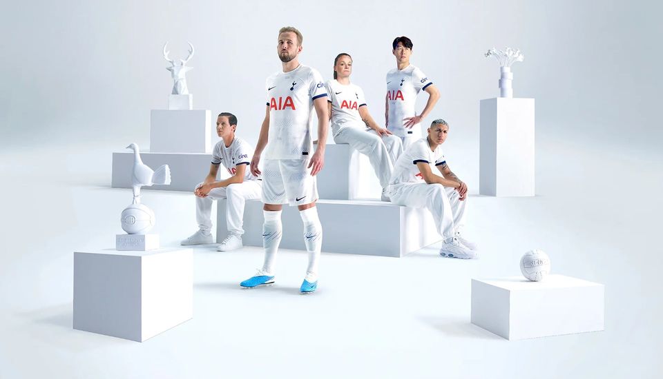 Neville, Kane, Percival, Son, and Richarlison model the new Spurs home kit, surrounded by white objects on pedestals.