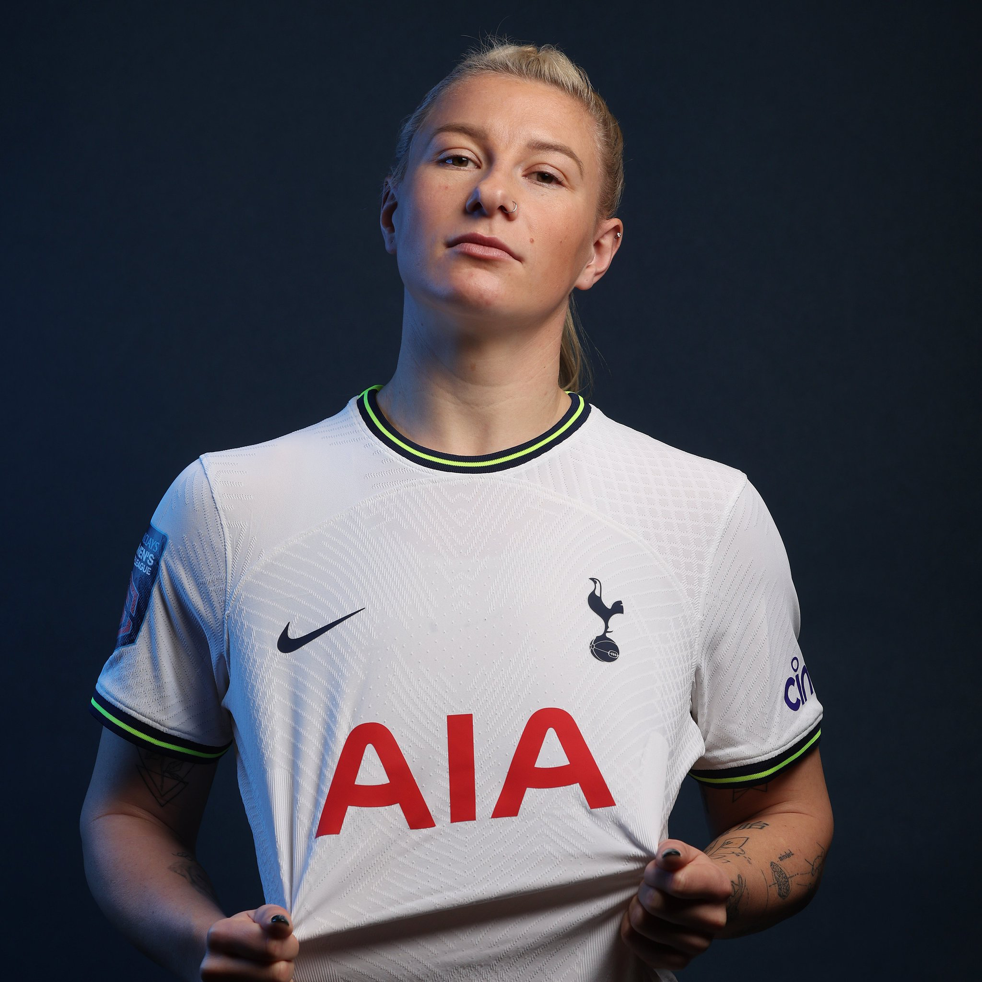 Beth England poses in her new Spurs kit, a determined expression on her face