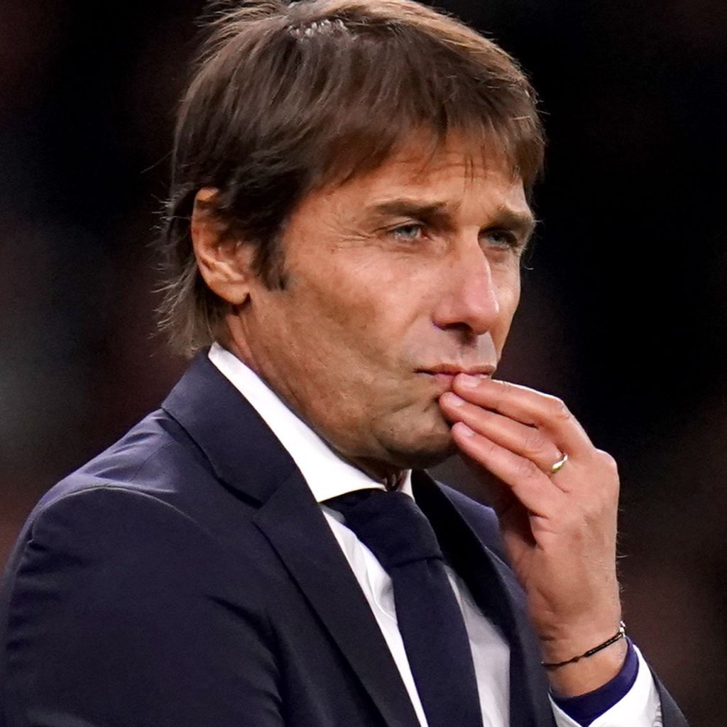 Conte holding his hand to his chin with a concerned expression.