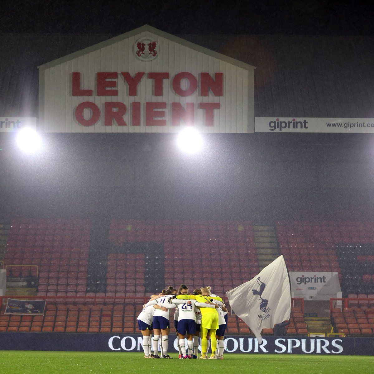 Spurs Women gather in a huddle on the pitch at Brisbane Road