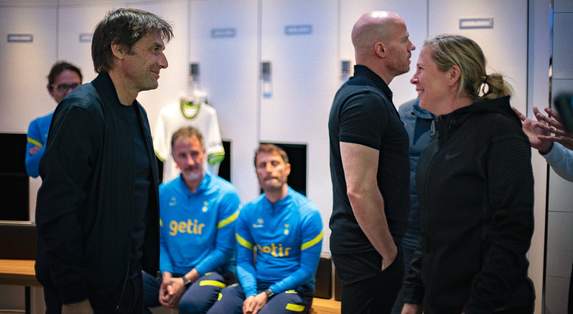 Antonio Conte and Rehanne Skinner face each other, smiling, in one of the Tottenham dressing rooms