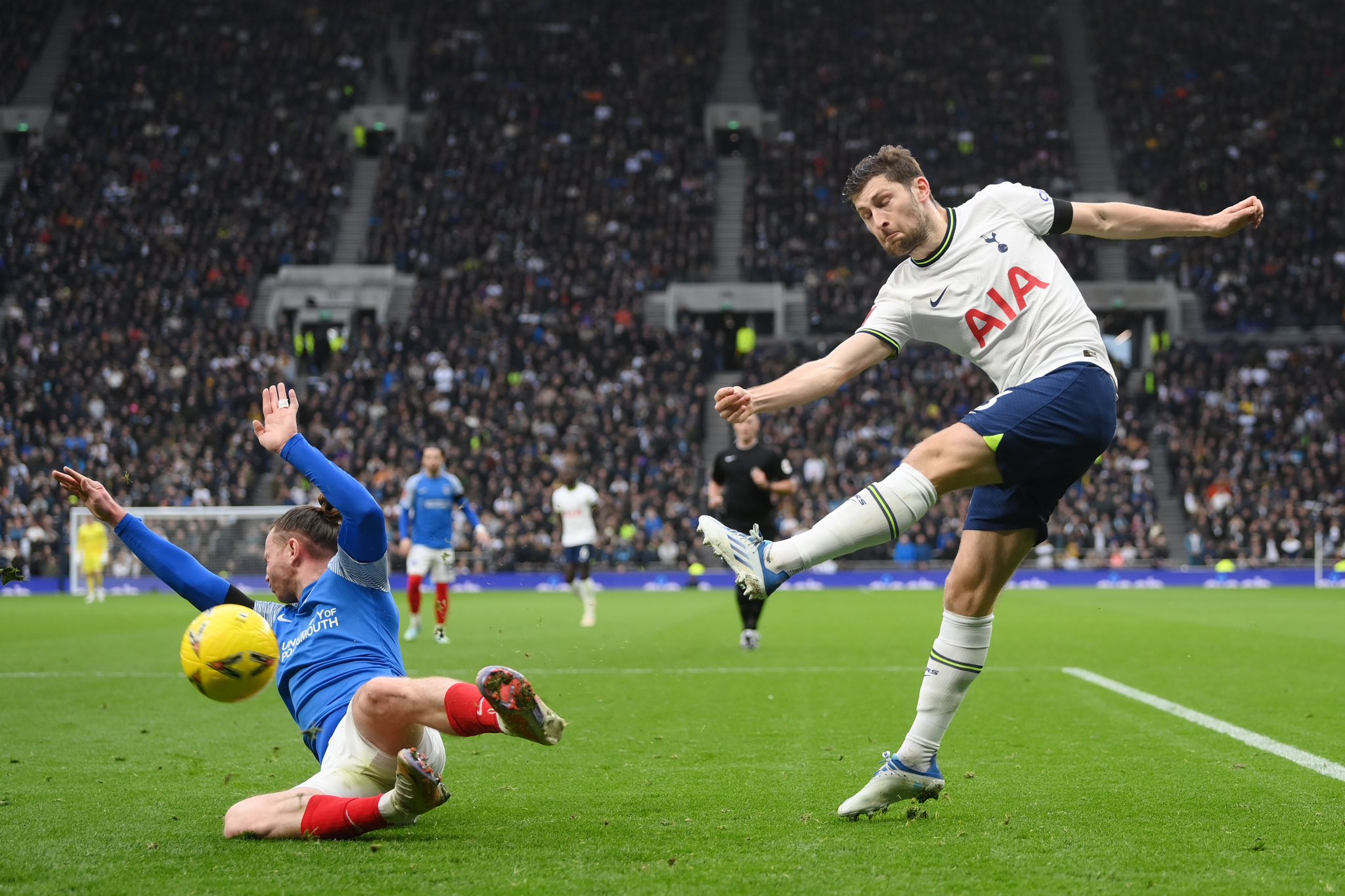 Ben Davies kicks the ball towards a falling Portsmouth player