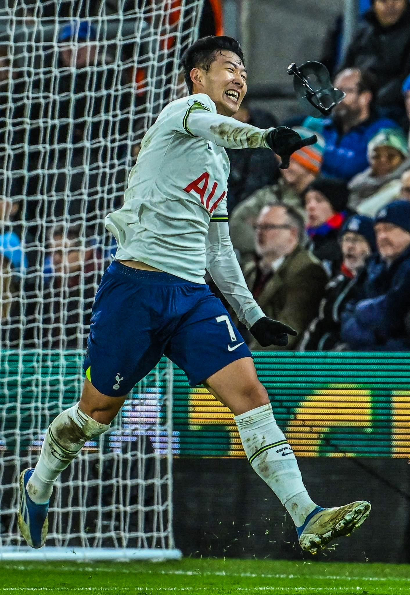 Son Heung-min tosses his protective face mask in triumph after scoring a goal.