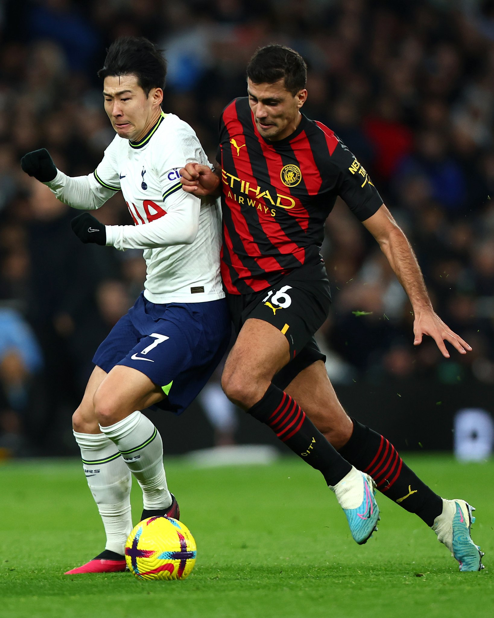 Son Heung-min fights to regain the ball from Rodri.