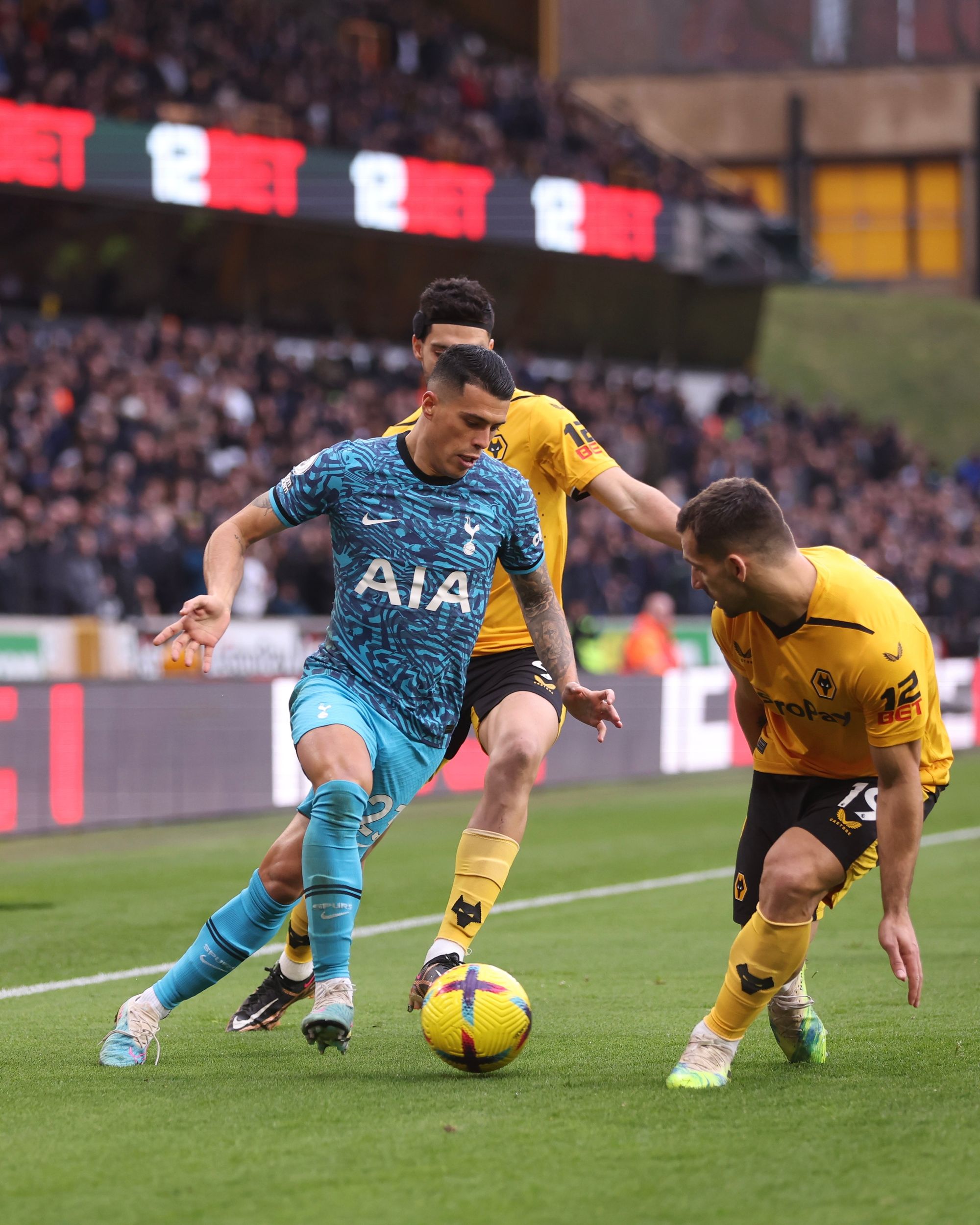 Pedro Porro dribbles past Wolves' Raul Jiménez and Jonny.