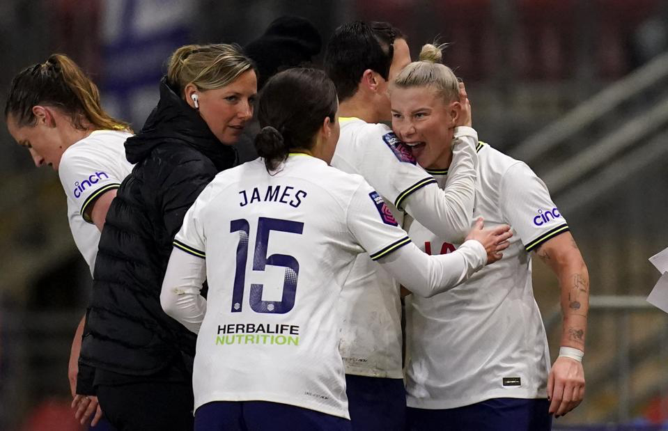 Beth England roars in triumph as she celebrates with Ash Neville and Angharad James, with Vicky Jepson looking on.