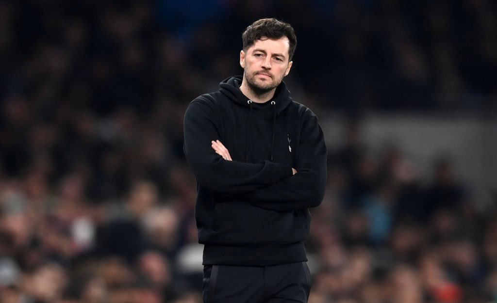 Ryan Mason wears a black Spurs-branded hoodie on the touchline.