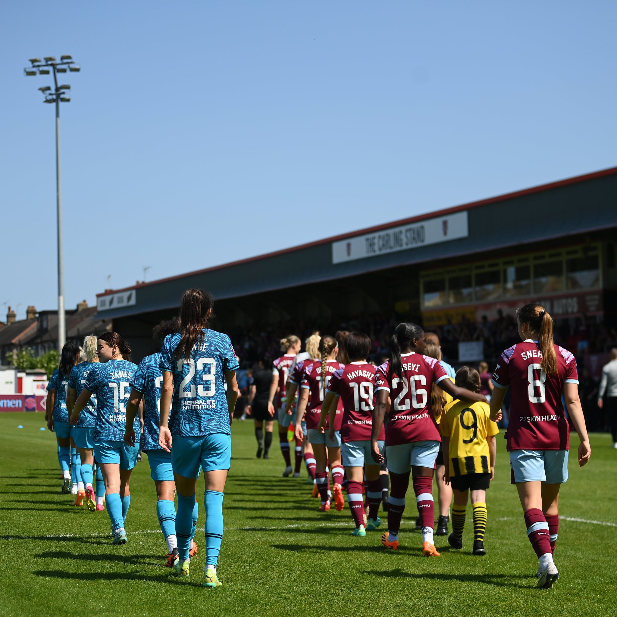 The starting XIs of Spurs Women and West Ham Women file onto the pitch before kickoff.