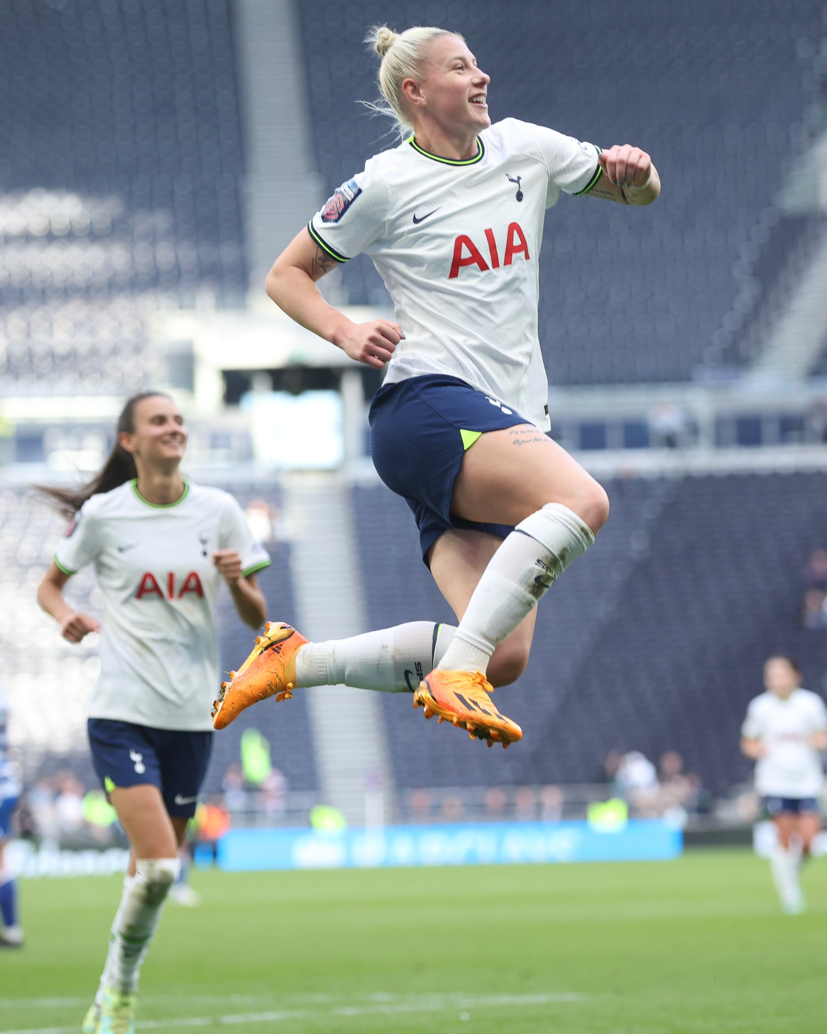 Beth England leaps into the air after scoring a goal.