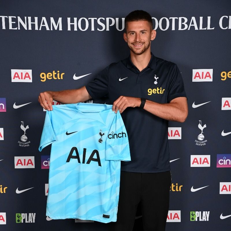 Guglielmo Vicario holds up his Spurs shirt.