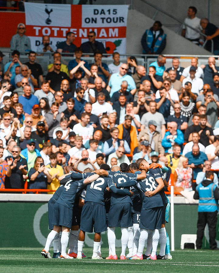 The starting XI do their pre-match huddle in front of the away fans at Brentford.