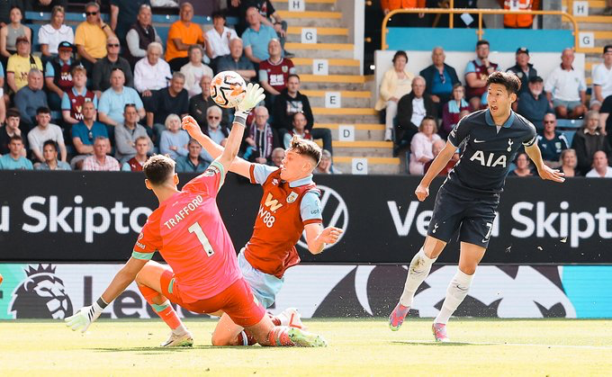 Son Heung-min chips a shot over Burnley's keeper, James Trafford.