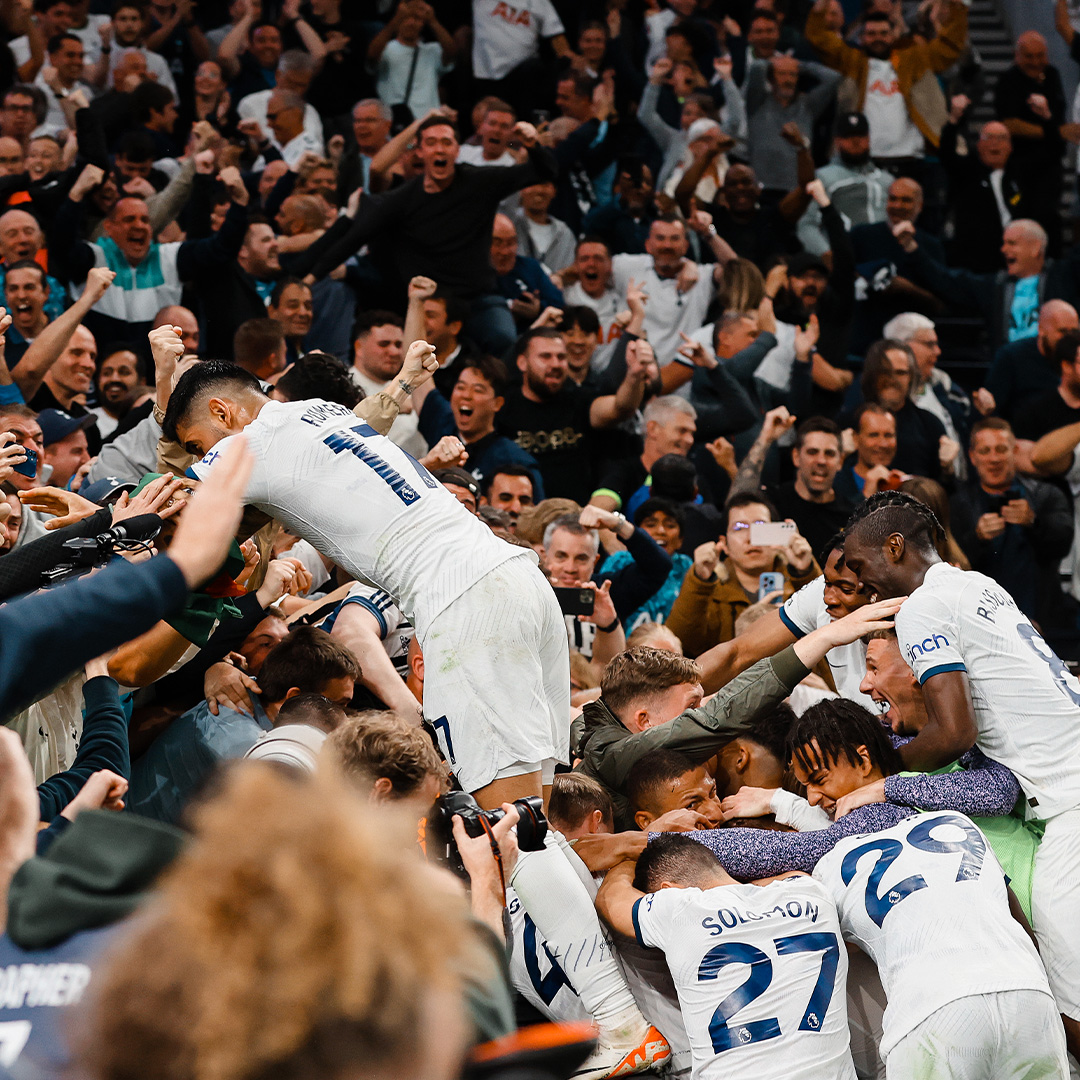 The players celebrate with fans behind the goal.