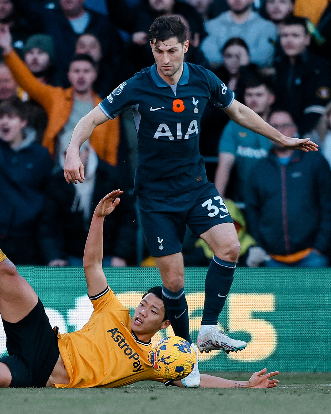 Ben Davies fights for the ball with Wolves' Hwang Hee-chan.