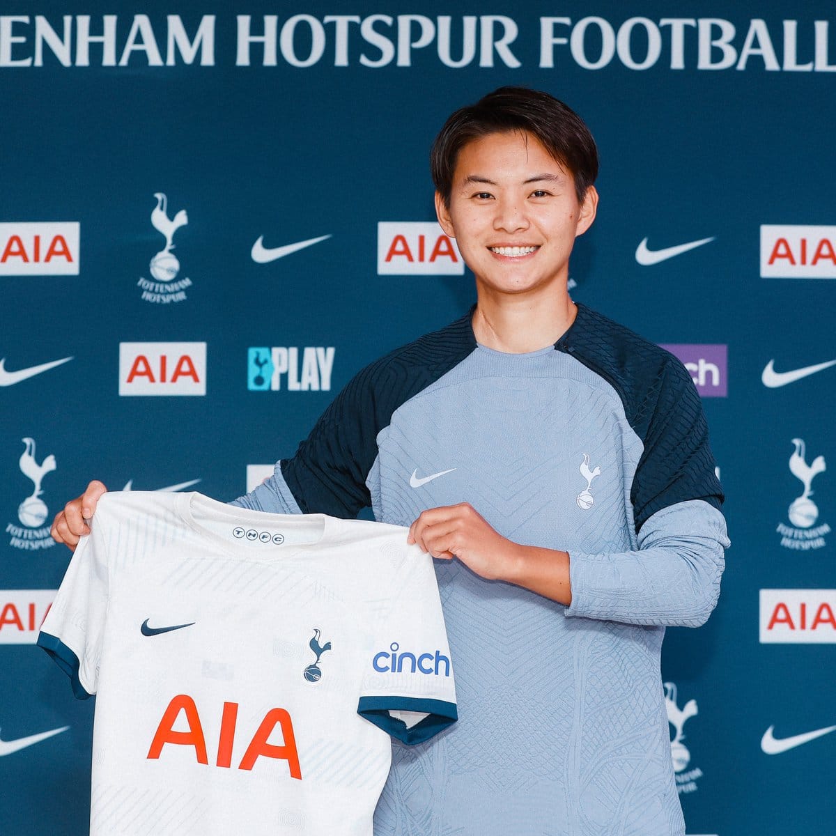 Shuang Wang holds up her first Spurs shirt after signing for the club.