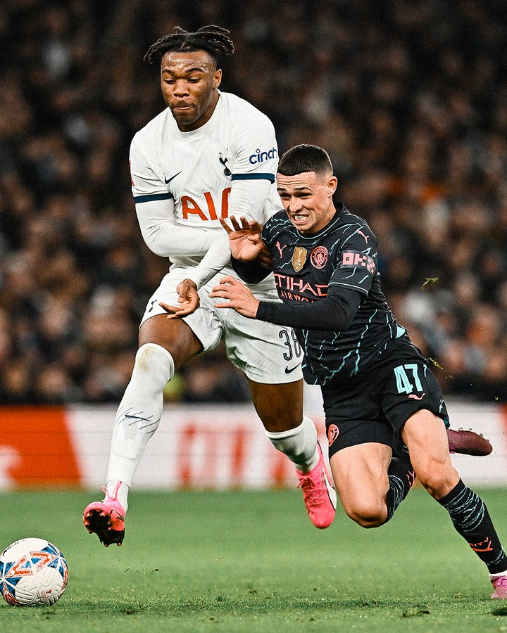 Destiny Udogie challenges Phil Foden for the ball.