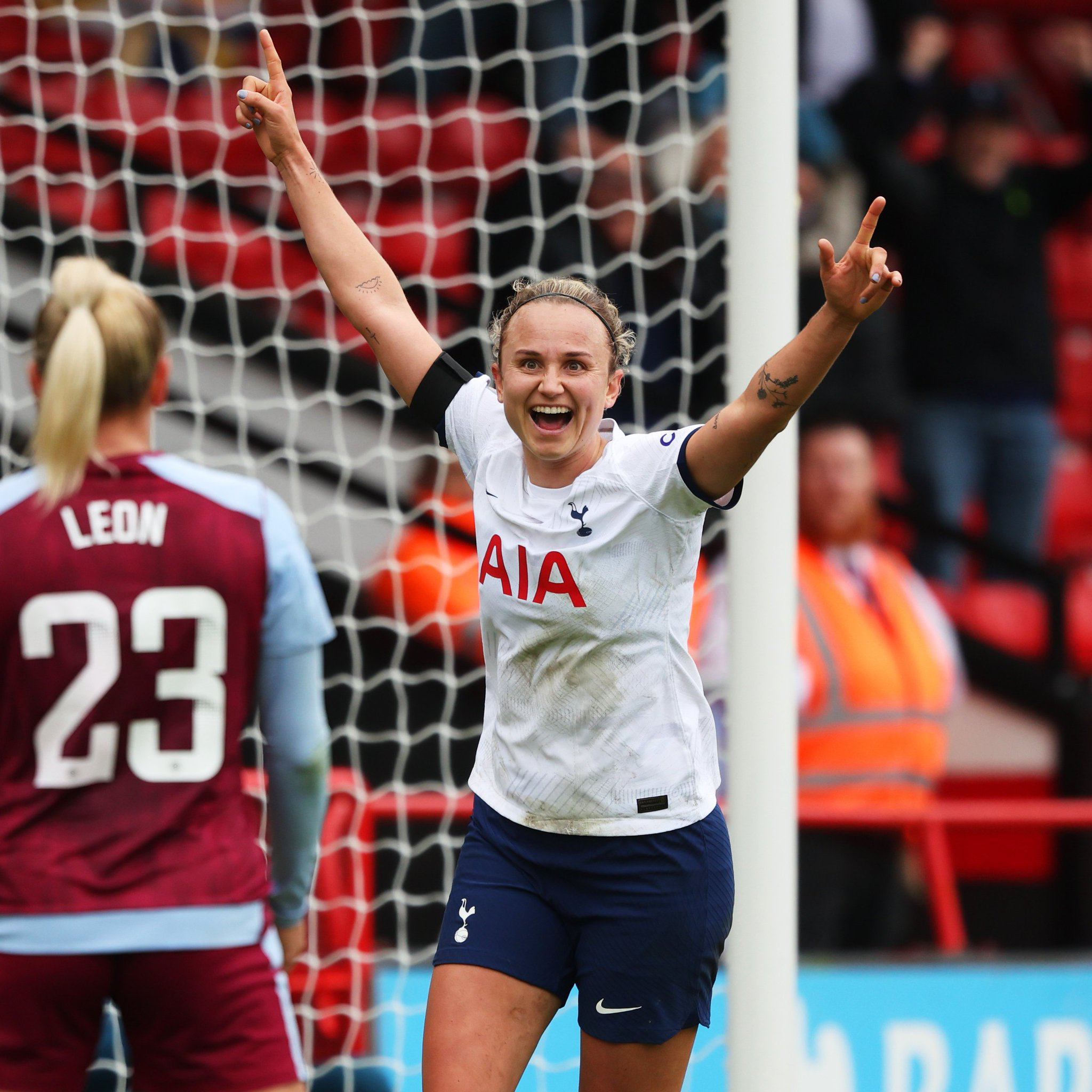 Martha Thomas holds her hands up to celebrate a goal.