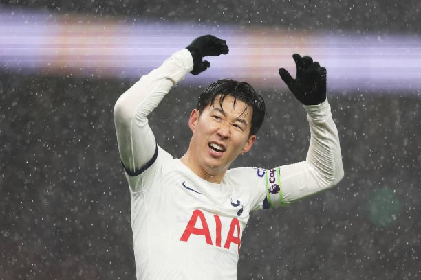 Son Heung-min raises his arms to celebrate.