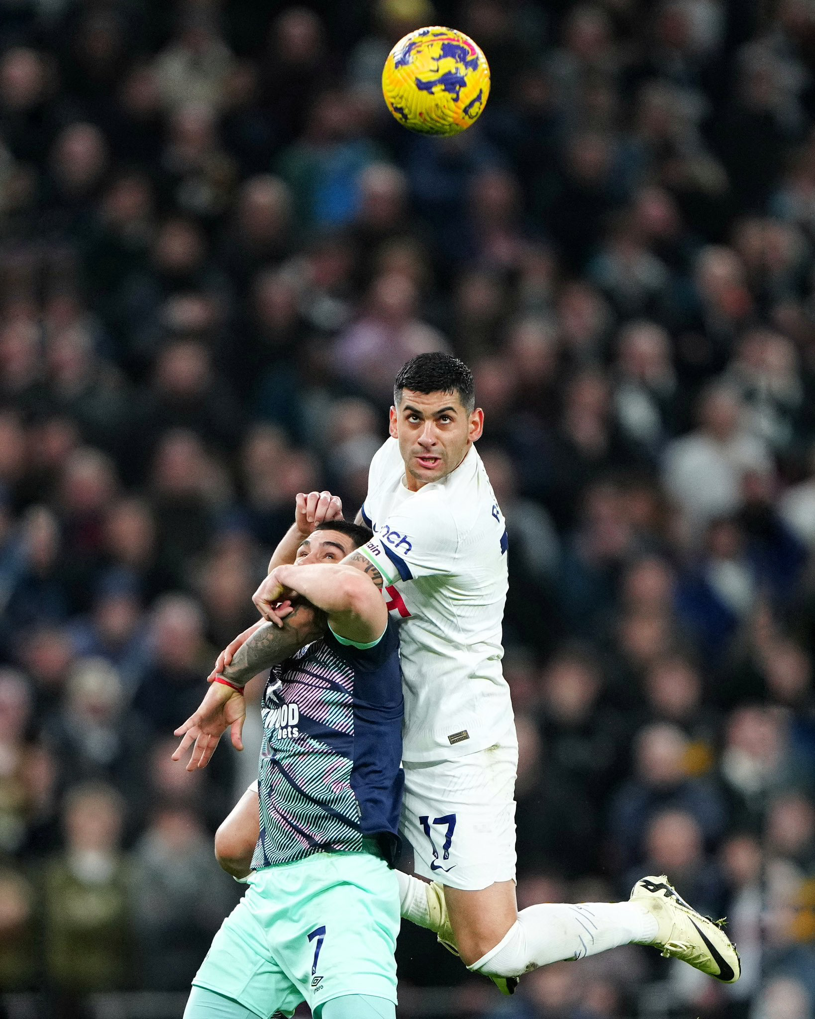 Cristian Romero rises to beat Neal Maupay to a header.