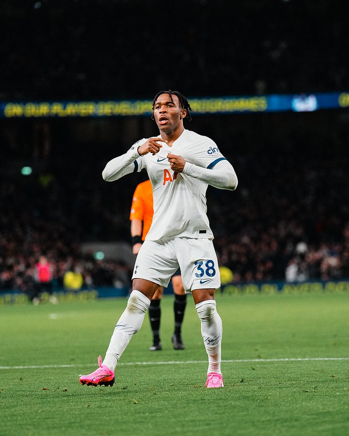 Destiny Udogie points to the Tottenham badge after scoring.