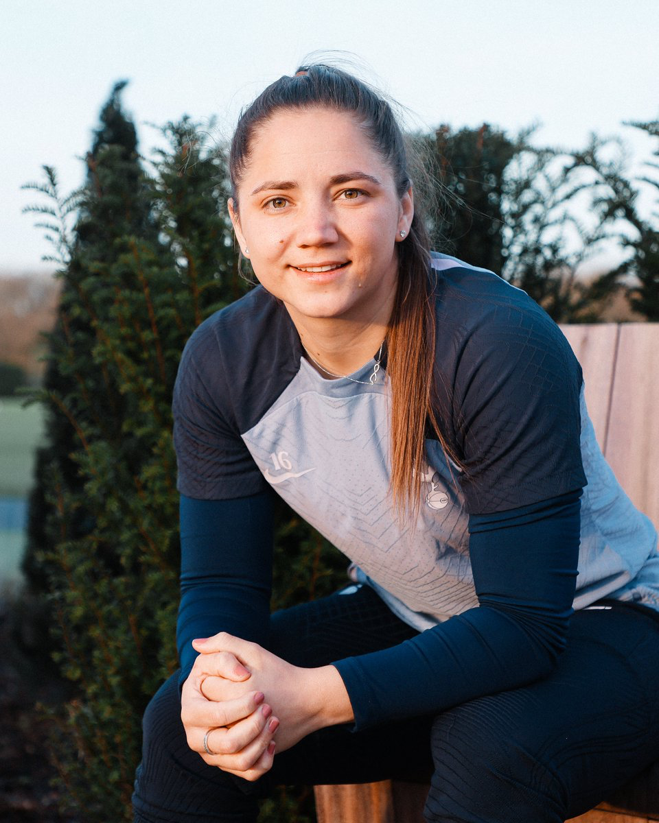 Kit Graham poses on a bench with her hands clasped.