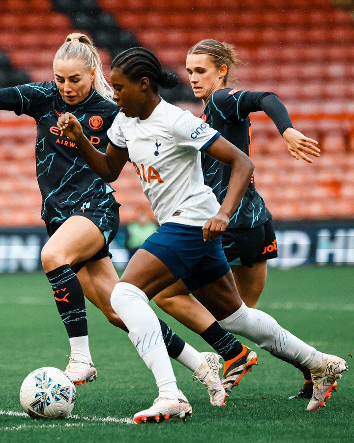 Jess Naz dribbles past two Manchester City players.