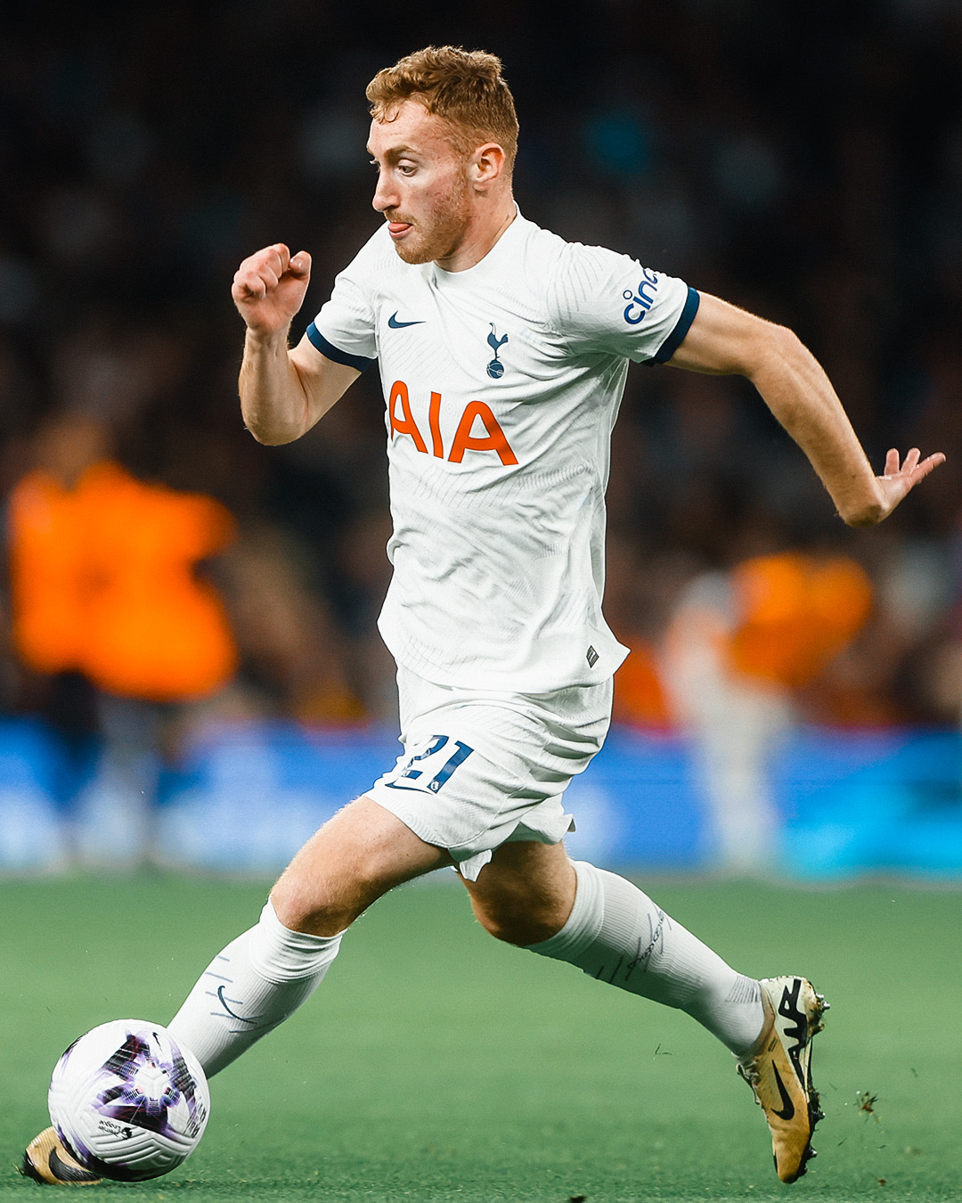 Dejan Kulusevski sticks his tongue out in concentration as he dribbles.