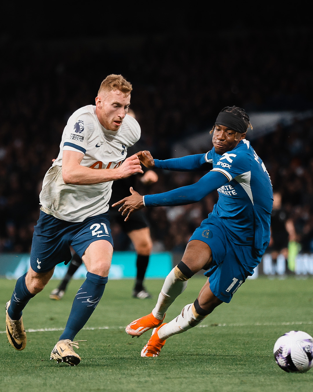 Dejan Kulusevski challenges Noni Madueke for the ball.