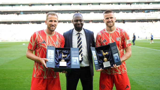 Ledley King stands between Harry Kane and Eric Dier, presenting them with commemorative objects.