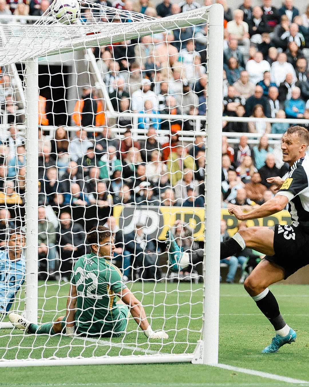 Dan Burn scores an own goal in Tottenham's favor, as Brennan Johnson and Nick Pope look on in the background.