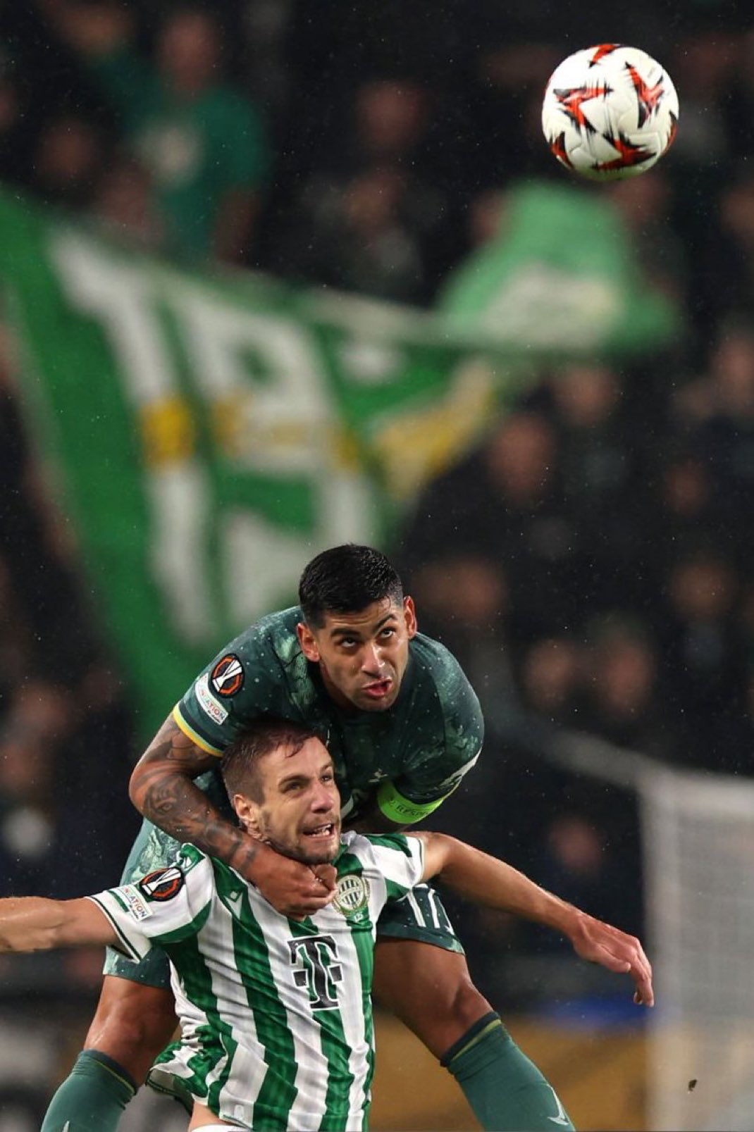 Cristian Romero nearly has Barnabas Varga in a headlock as they challenge for an aerial ball.