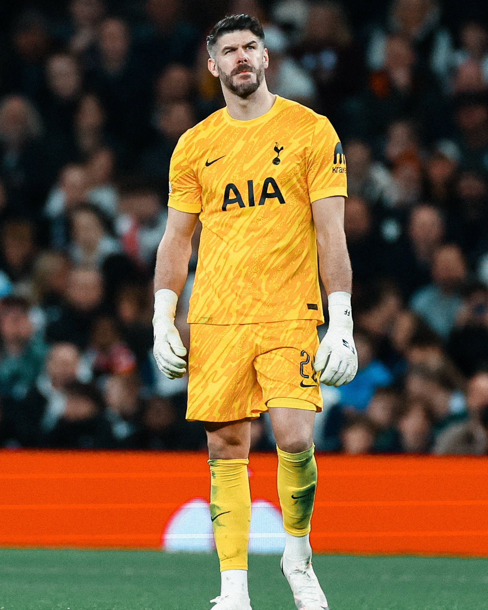 Fraser Forster looks across the pitch in his yellow keeper kit.