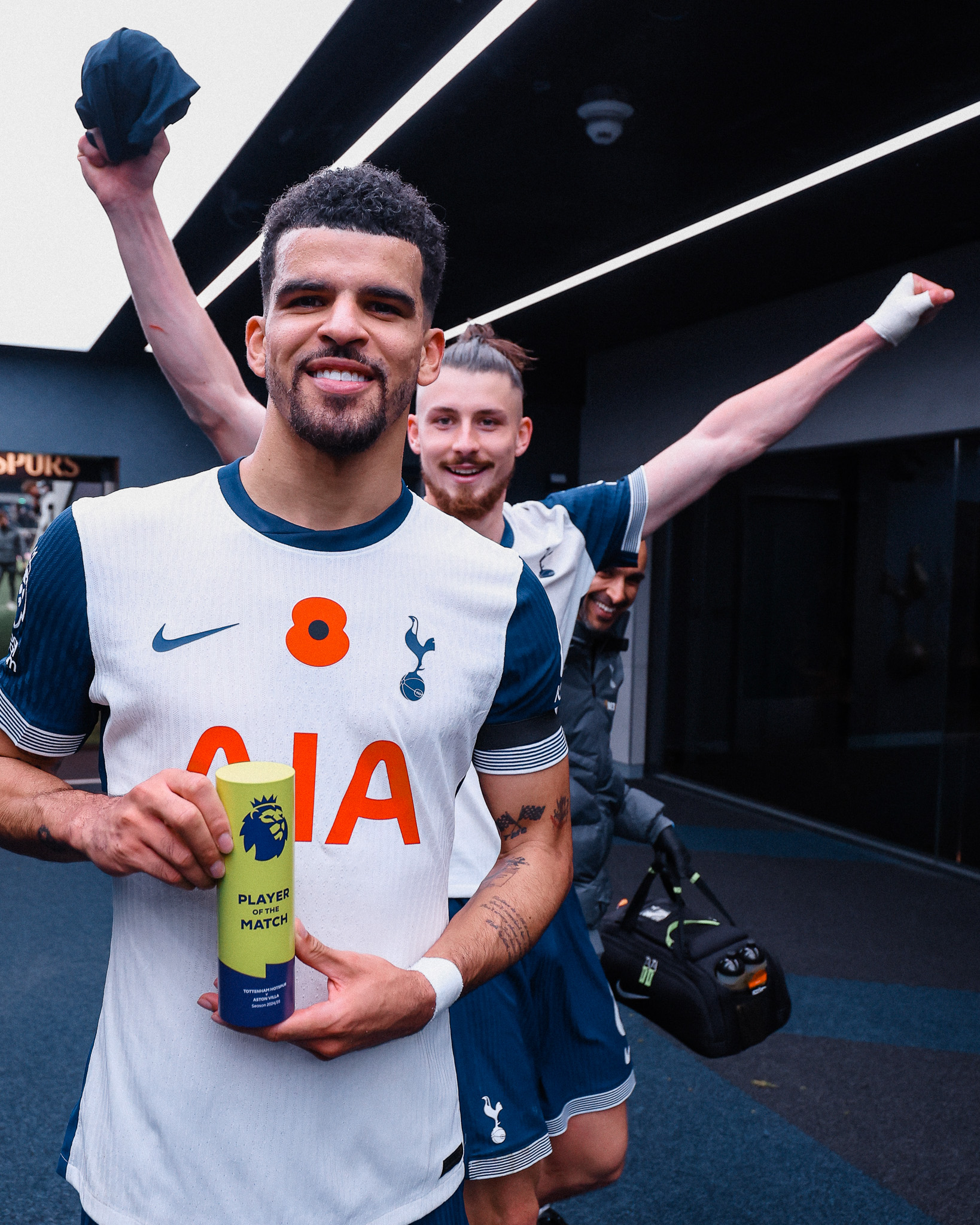 Dominic Solanke holds up his player of the match award while Radu Drăgușin raises his hands behind him.