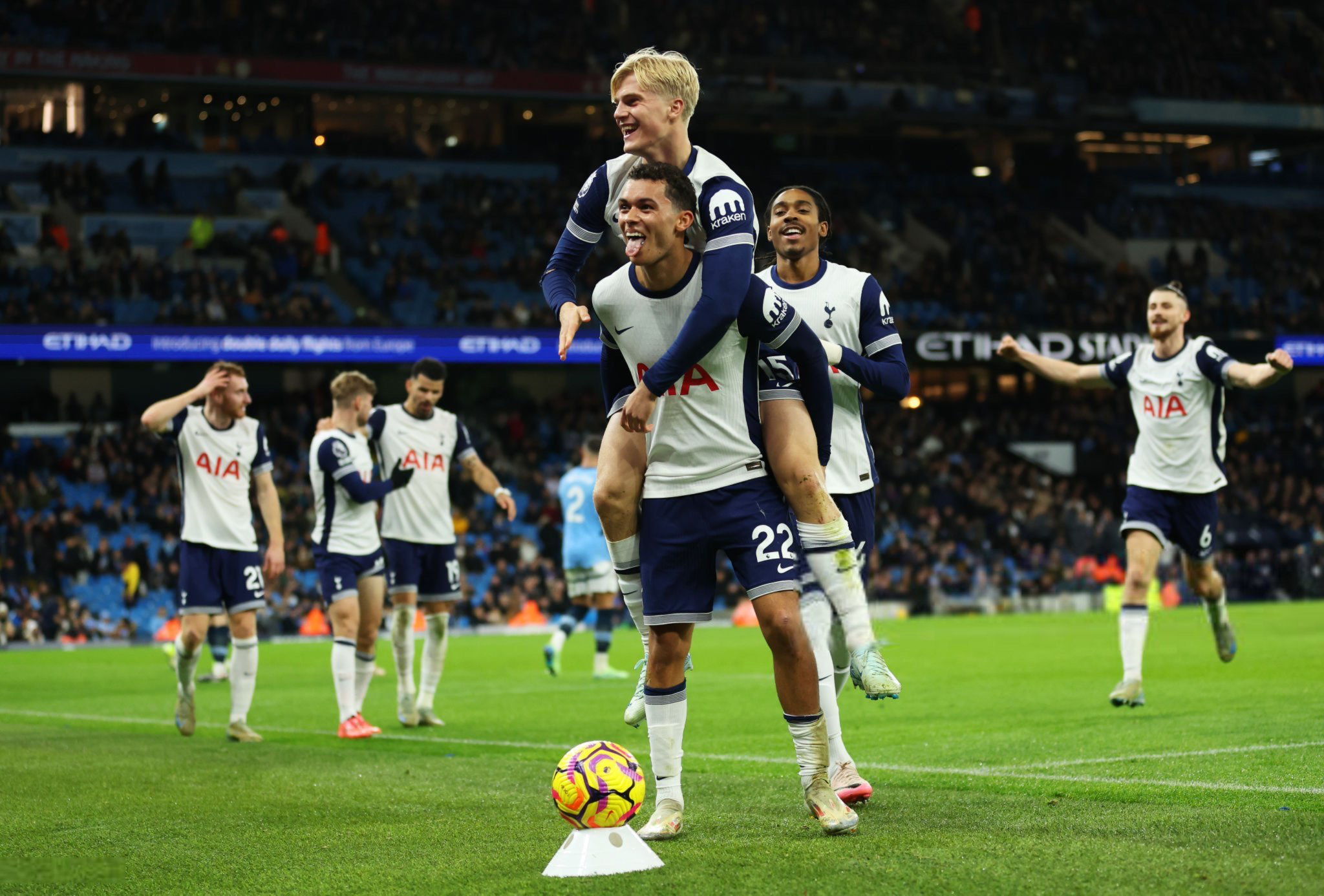 Several players approach to join the celebrations as Lucas Bergvall jumps on Brennan Johnson's back, who is sticking his tongue out playfully.