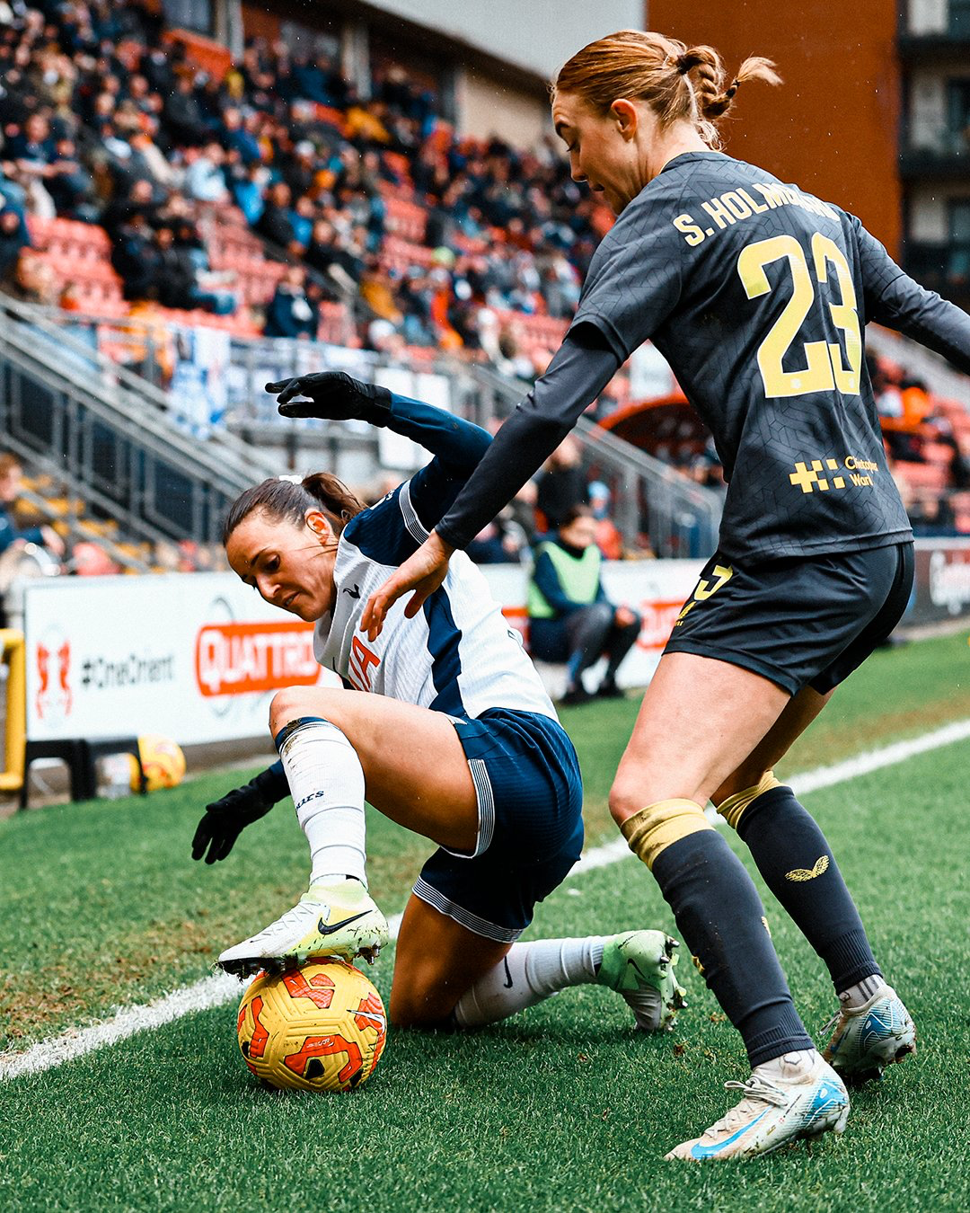 Hayley Raso gets down low to challenge Sara Holmgaard for a ball near the touchline.