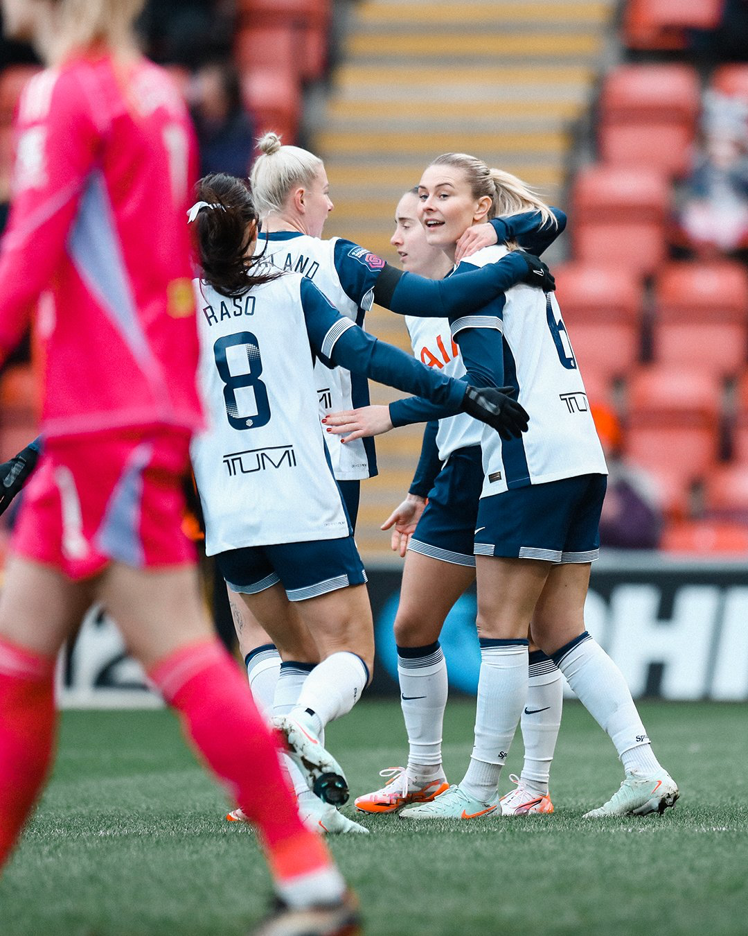 Amanda Nildén smiles as teammates put their arms around her.