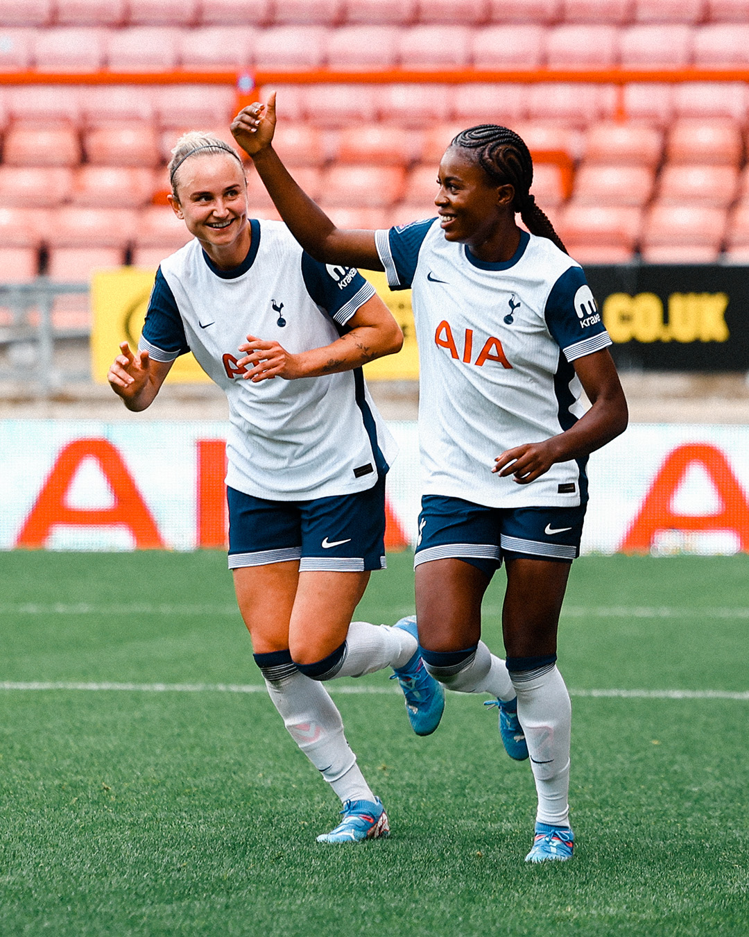 Martha Thomas smiles at Jess Naz, who raises her hand to beckon the rest of the team for a goal celebration.