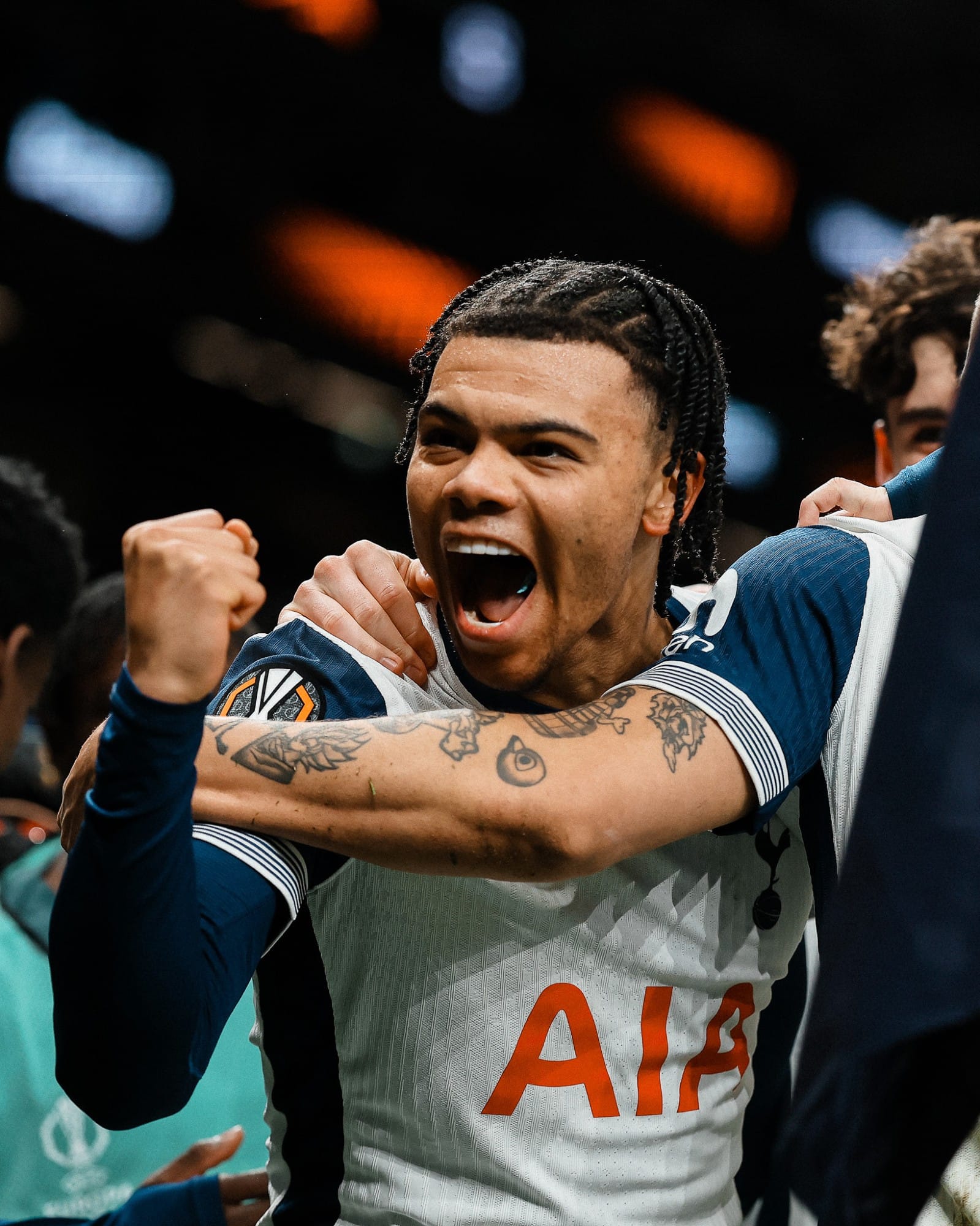 Dane Scarlett celebrates scoring his first Spurs goal by raising his fist, a teammate's tattooed arm around him.