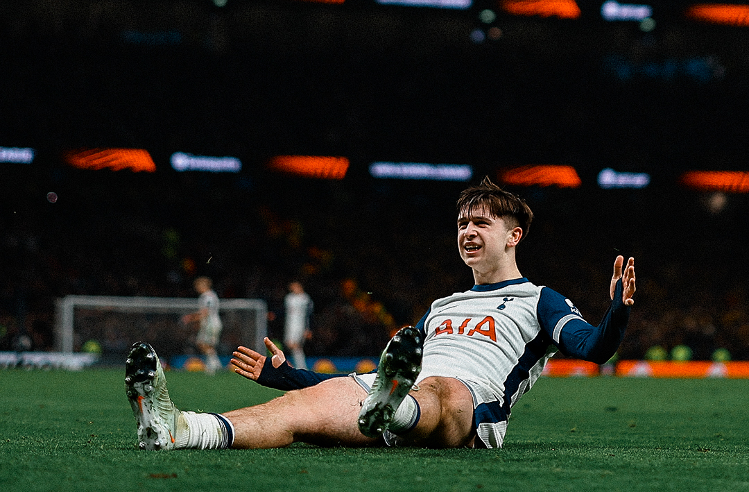 Mikey Moore slides on the grass toward the home fans.