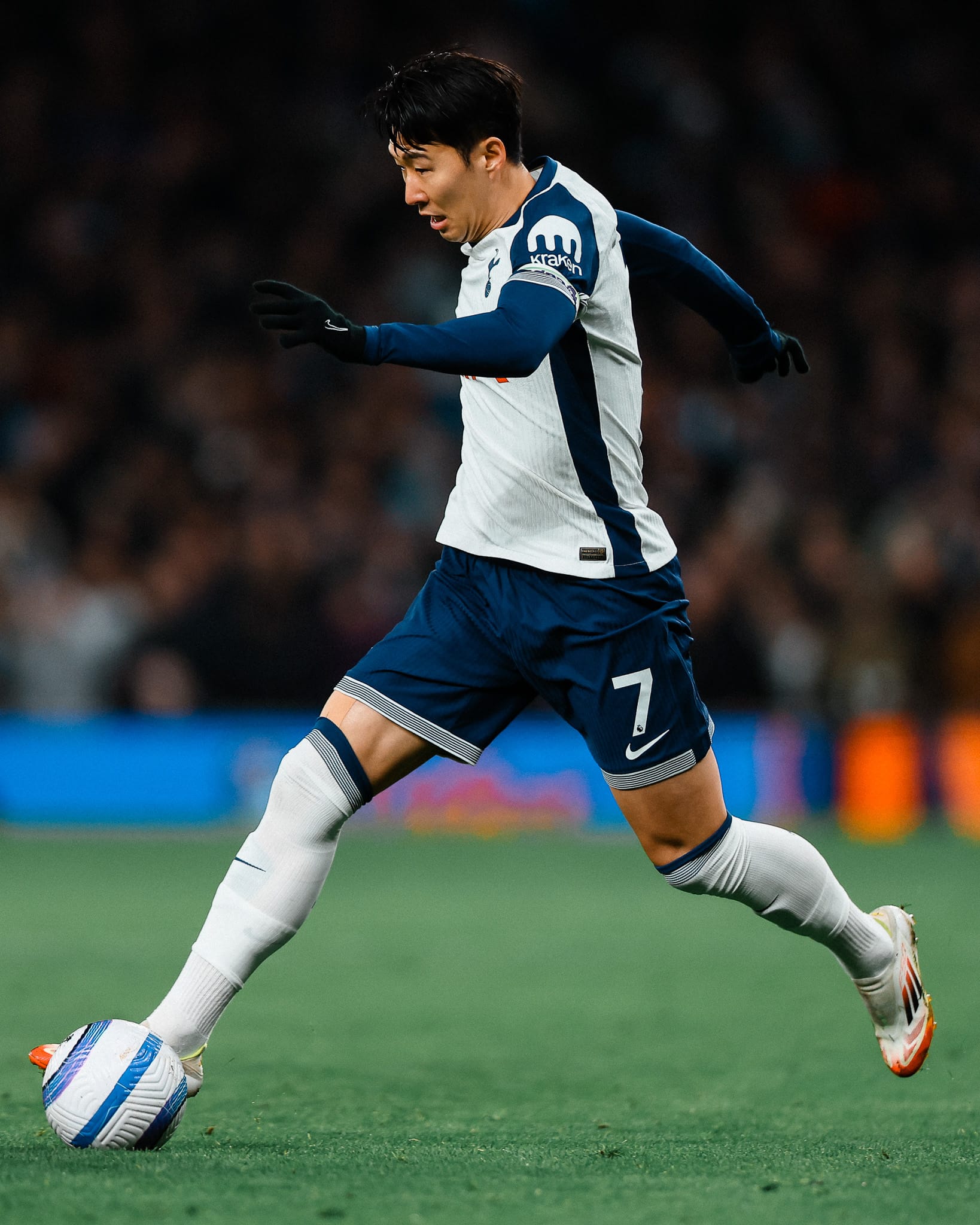 Son Heung-min takes a long stride with the ball. 