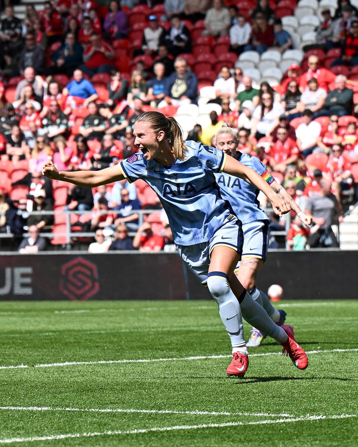 Clare Hunt holds out a fist and roars in delight after scoring.