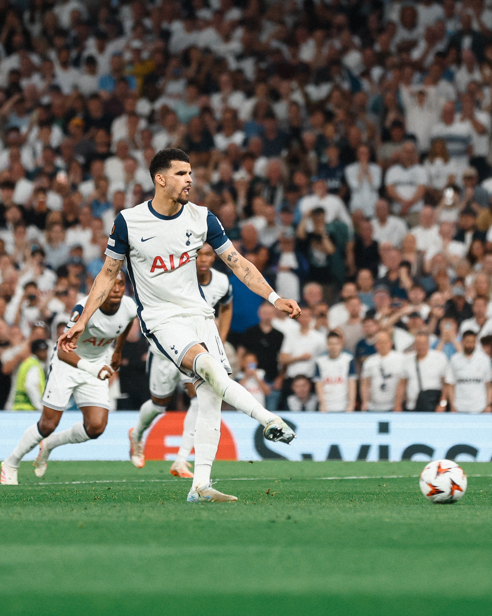 Dominic Solanke sticks out his tongue as he takes a penalty kick.
