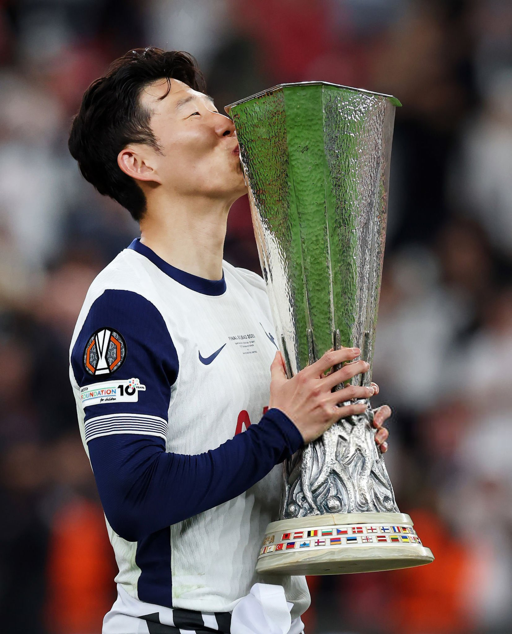 Son Heung-min kisses the Europa League trophy.