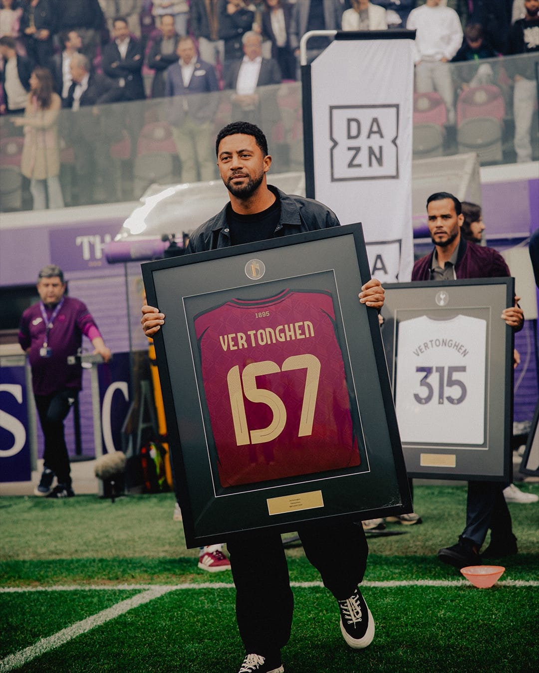 Mousa Dembélé and Michel Vorm carry commemorative Vertonghon trophies in frame onto the pitch.