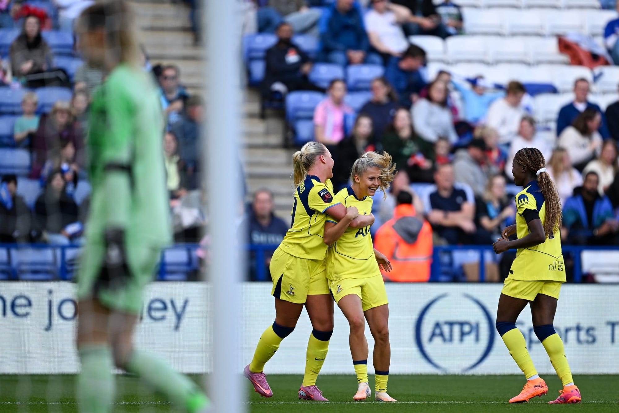 Cathinka Tandberg hugs Olivia Holdt from behind as Jess Naz runs up to them both.