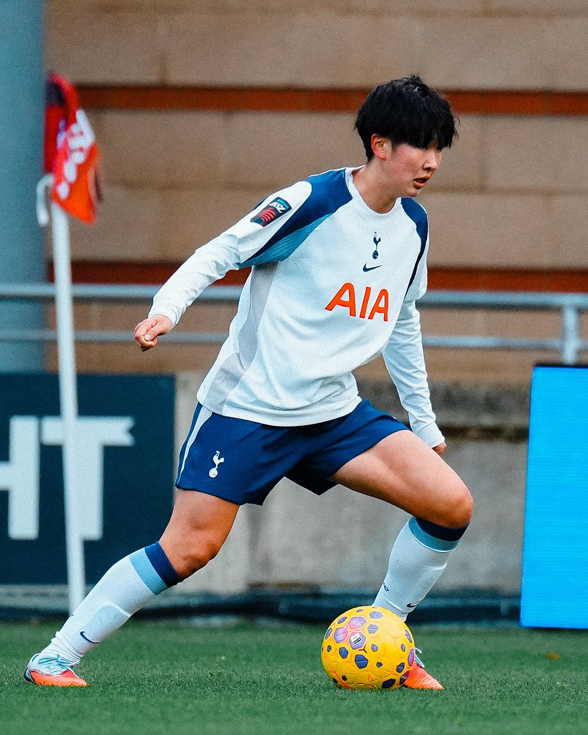 Tōko Koga lunges with the ball at her feet. 