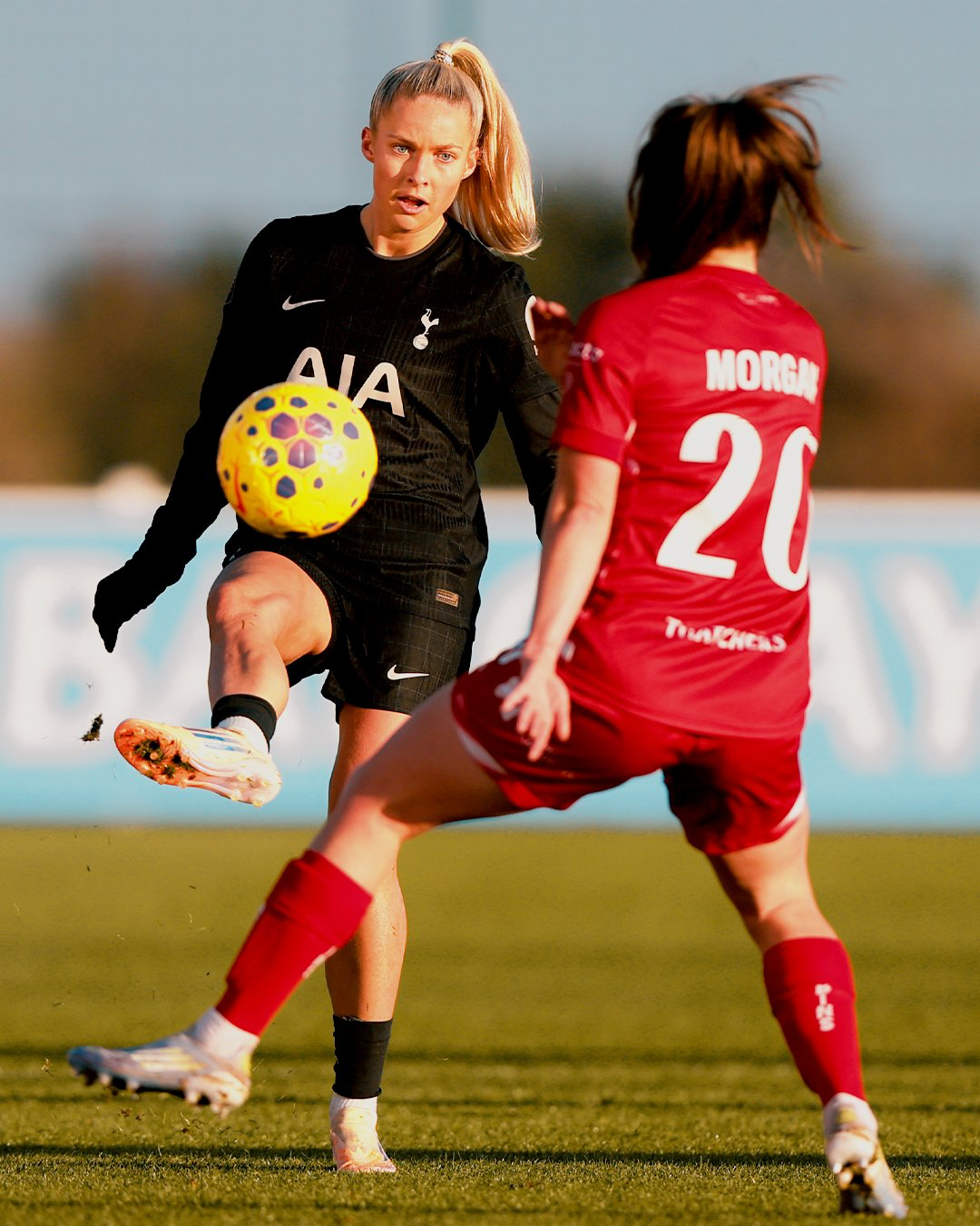 Former Spurs player Esther Morgan moves to block a kick from Olivia Holdt. 