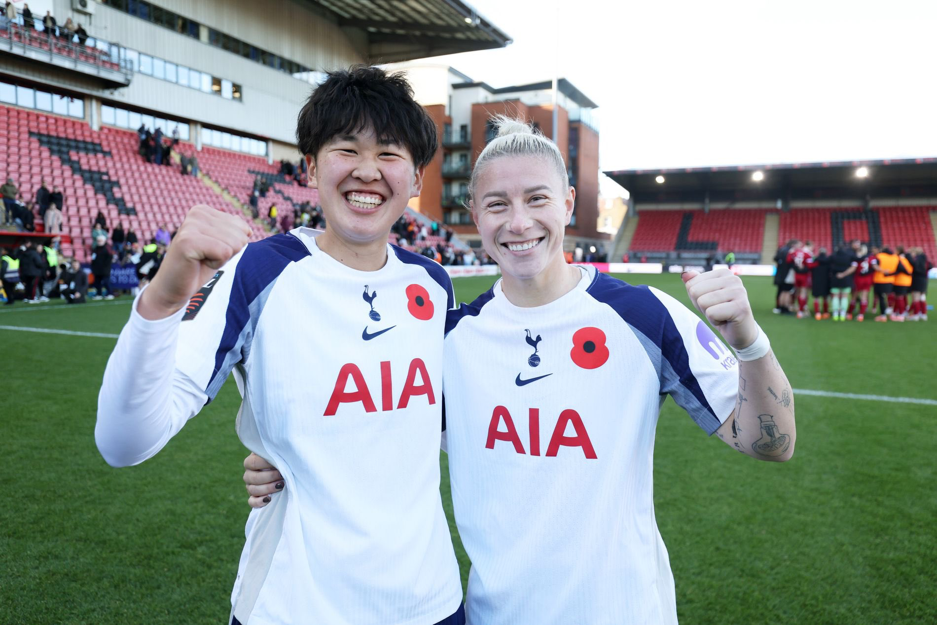 Goalscorers Tōko Koga and Beth England hug and raise one fist each. 