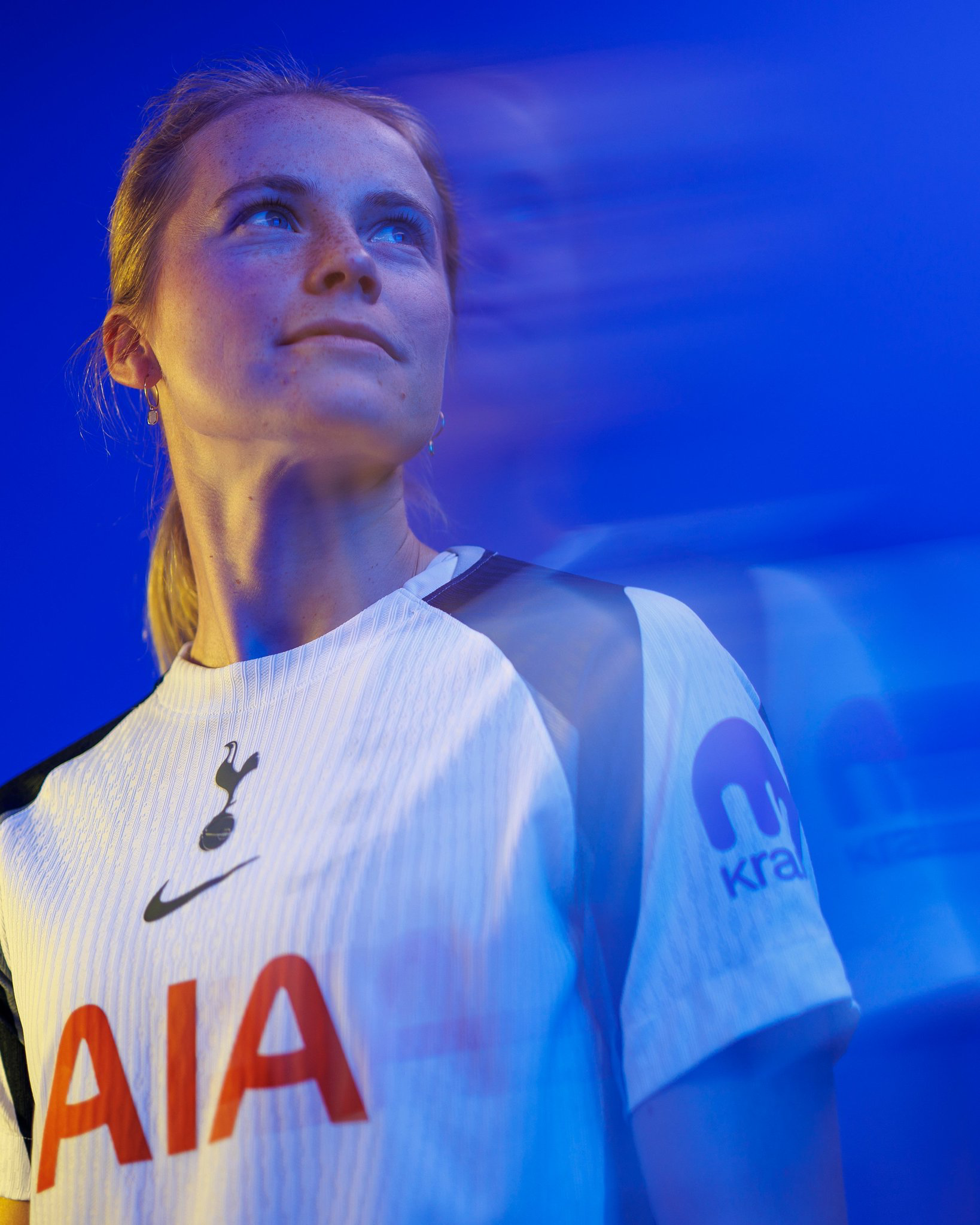 Julie Blakstad looks into the distance in front of a blurry blue background.