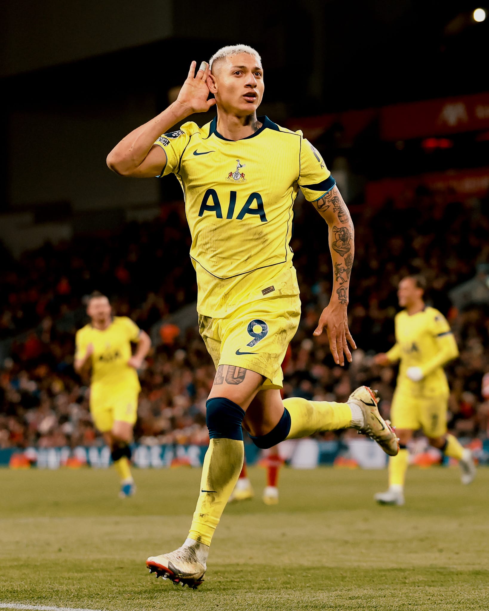 Richarlison cups his ear after scoring a goal.